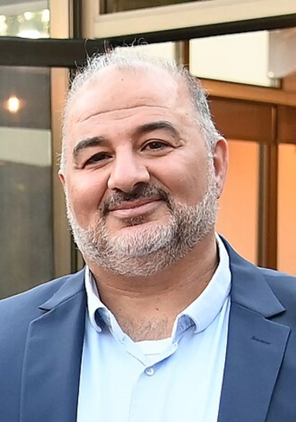 מנסור עבאס, יו"ר רע"מ, מחייך בחליפה כחולה